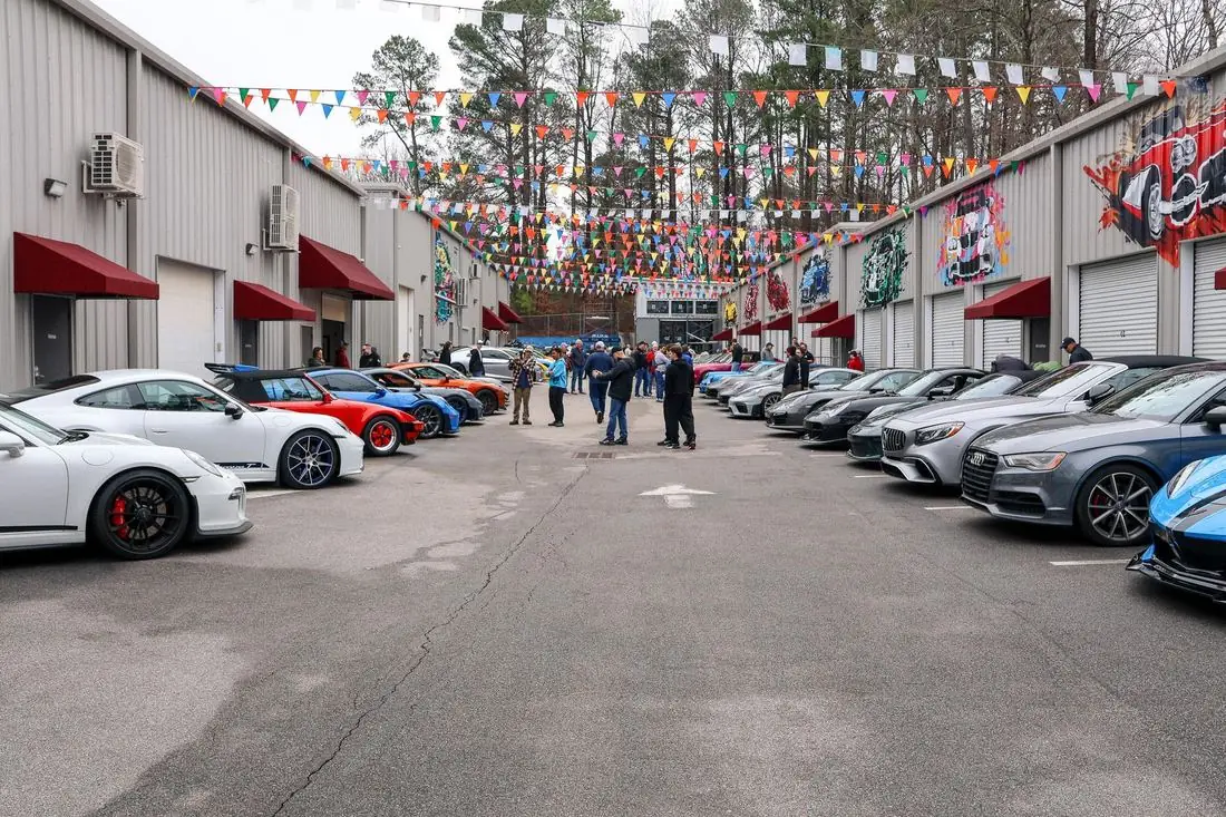 The monthly Exotic Car Show filling the CECC courtyard, bunting overhead and murals on the garage doors